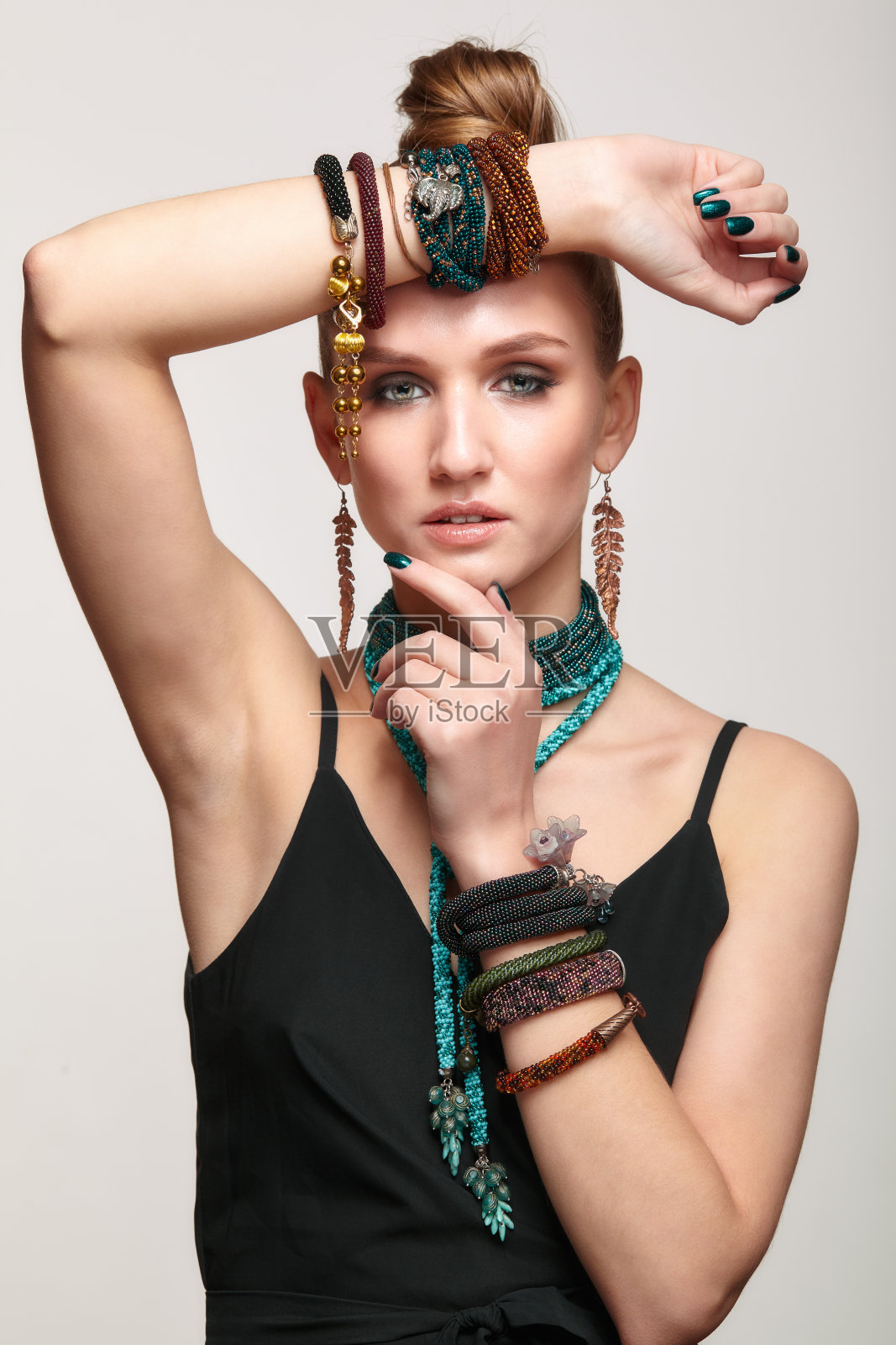 漂亮的女人在领项链和多个手镯。照片摄影图片