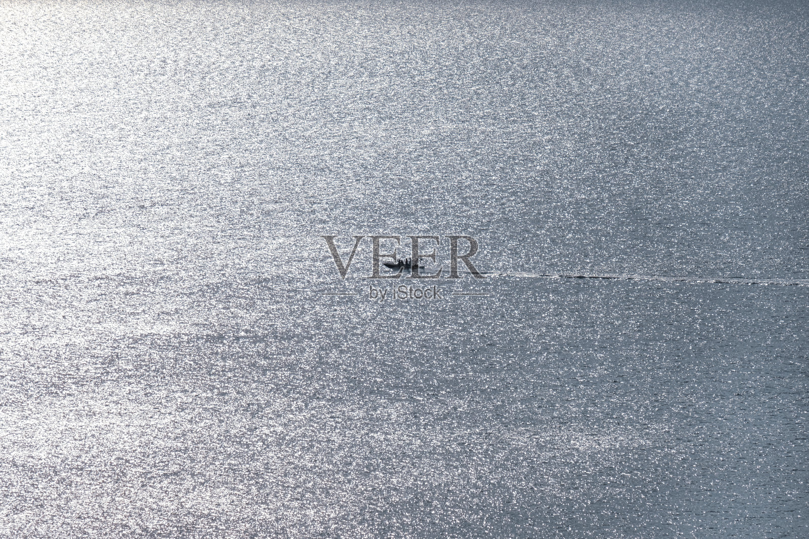 空中远眺:远处的摩托艇在大海、大湖或江河的波涛中高速行驶，奔向夕阳照片摄影图片