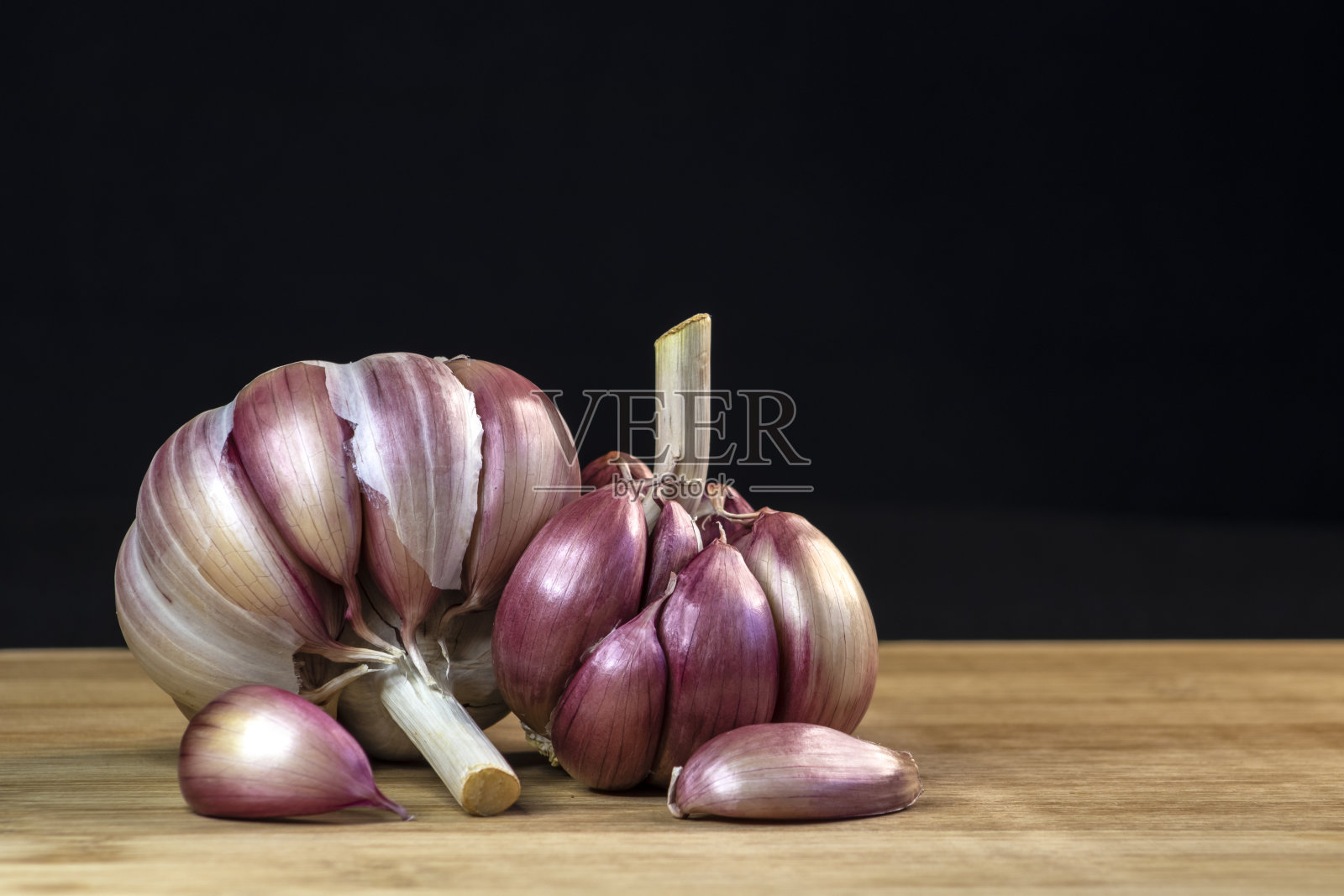 木桌上放着蒜瓣和球茎照片摄影图片