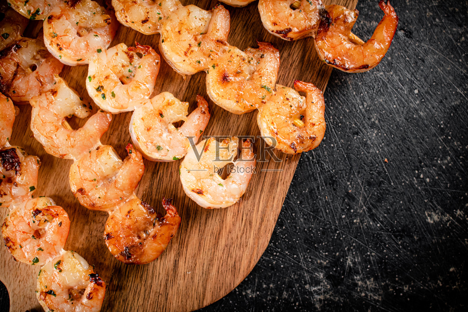 在木切菜板上烤虾。照片摄影图片