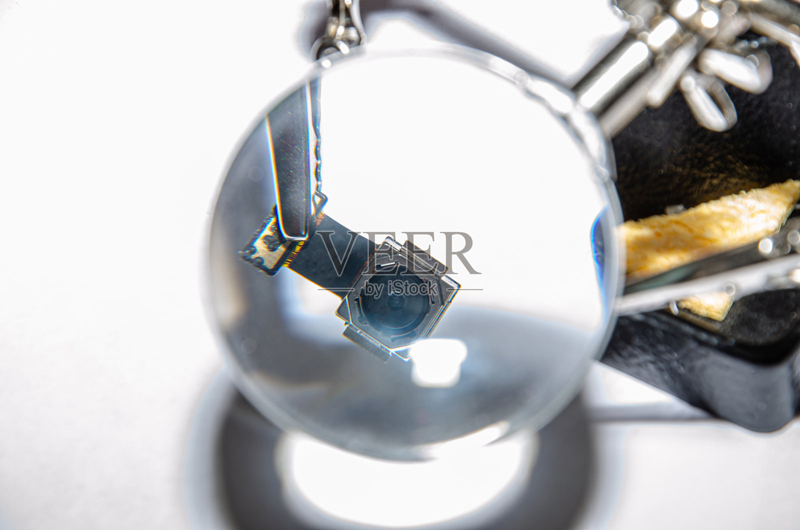 固定电话。一个技术人员或师傅修理手机，他安装和更换主板上的摄像头。照片摄影图片