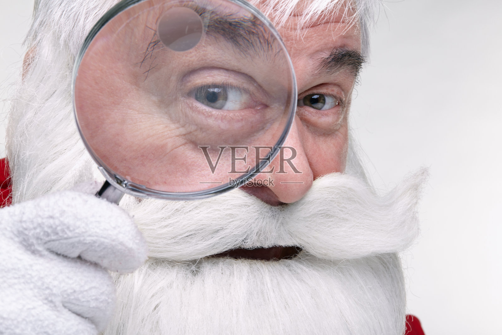圣诞老人通过放大镜看镜头照片摄影图片