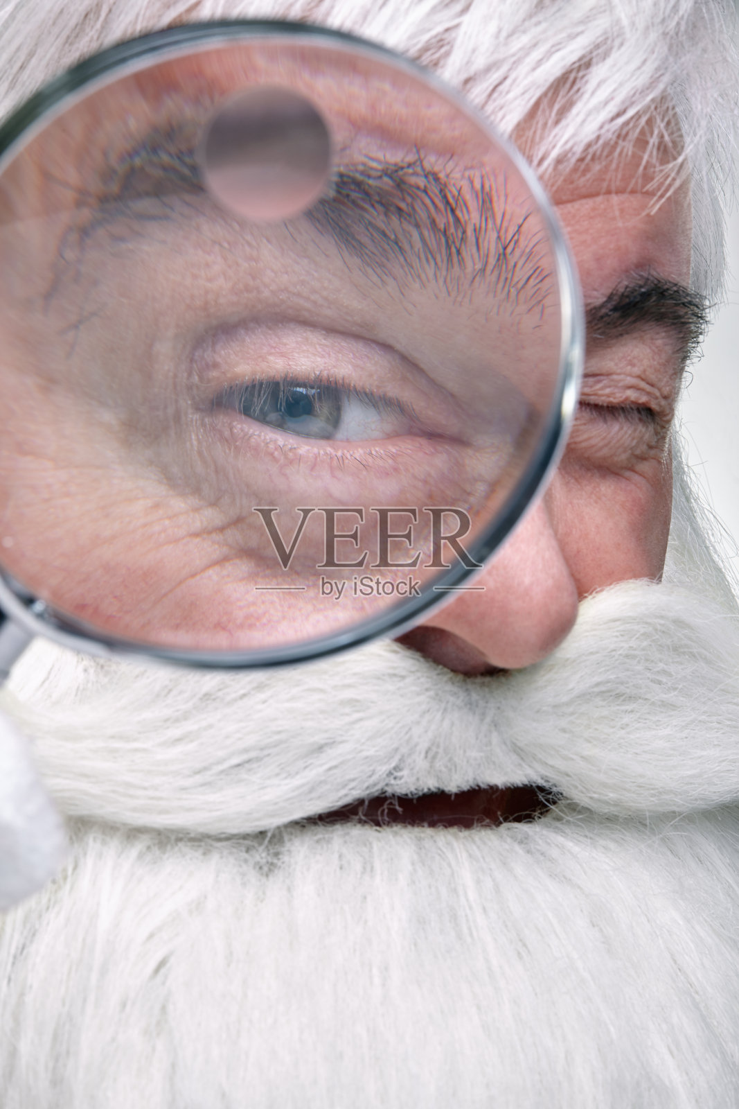 圣诞老人通过放大镜看镜头照片摄影图片