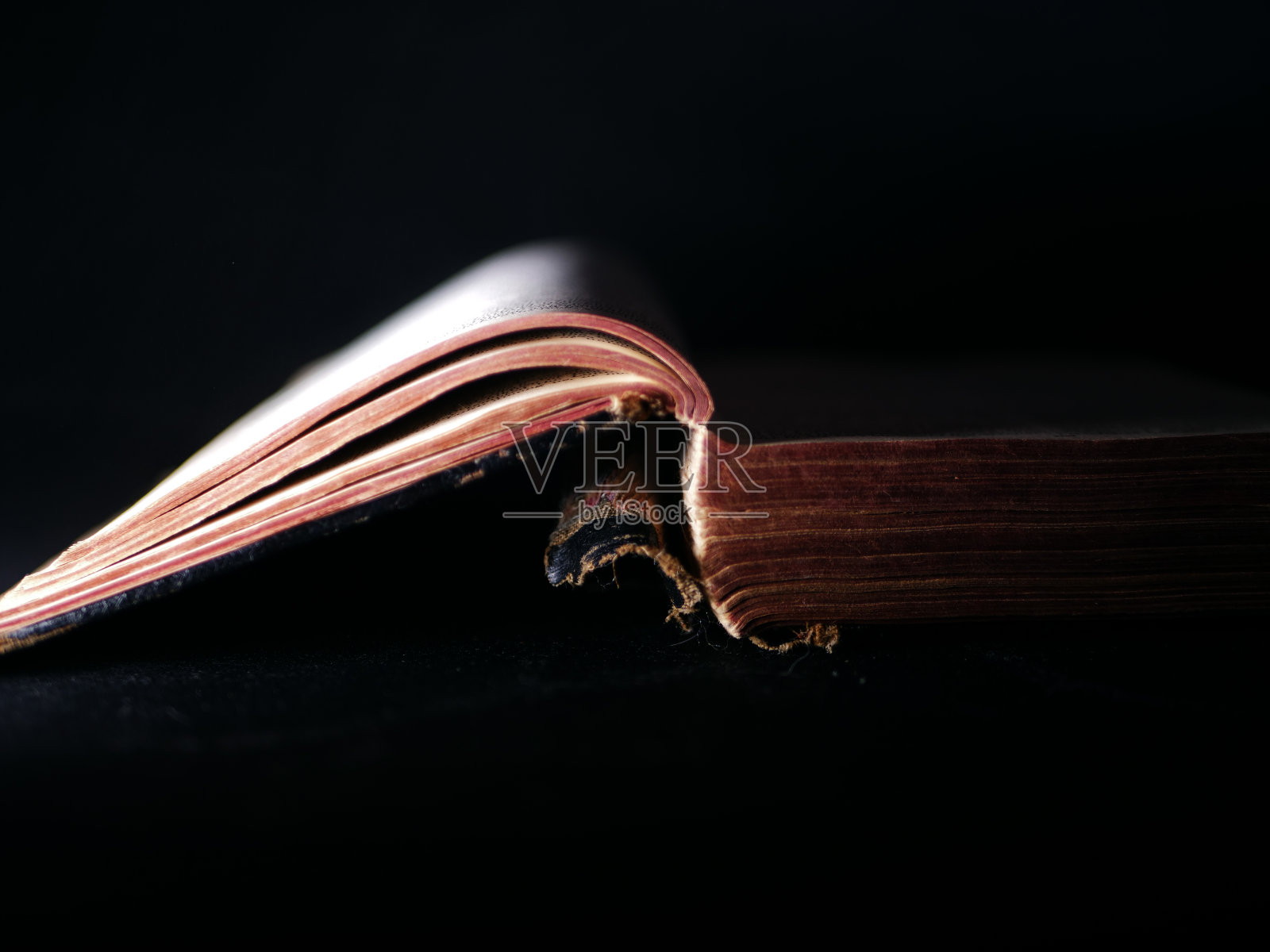 旧的破旧的打开的书在黑暗的背景照片摄影图片