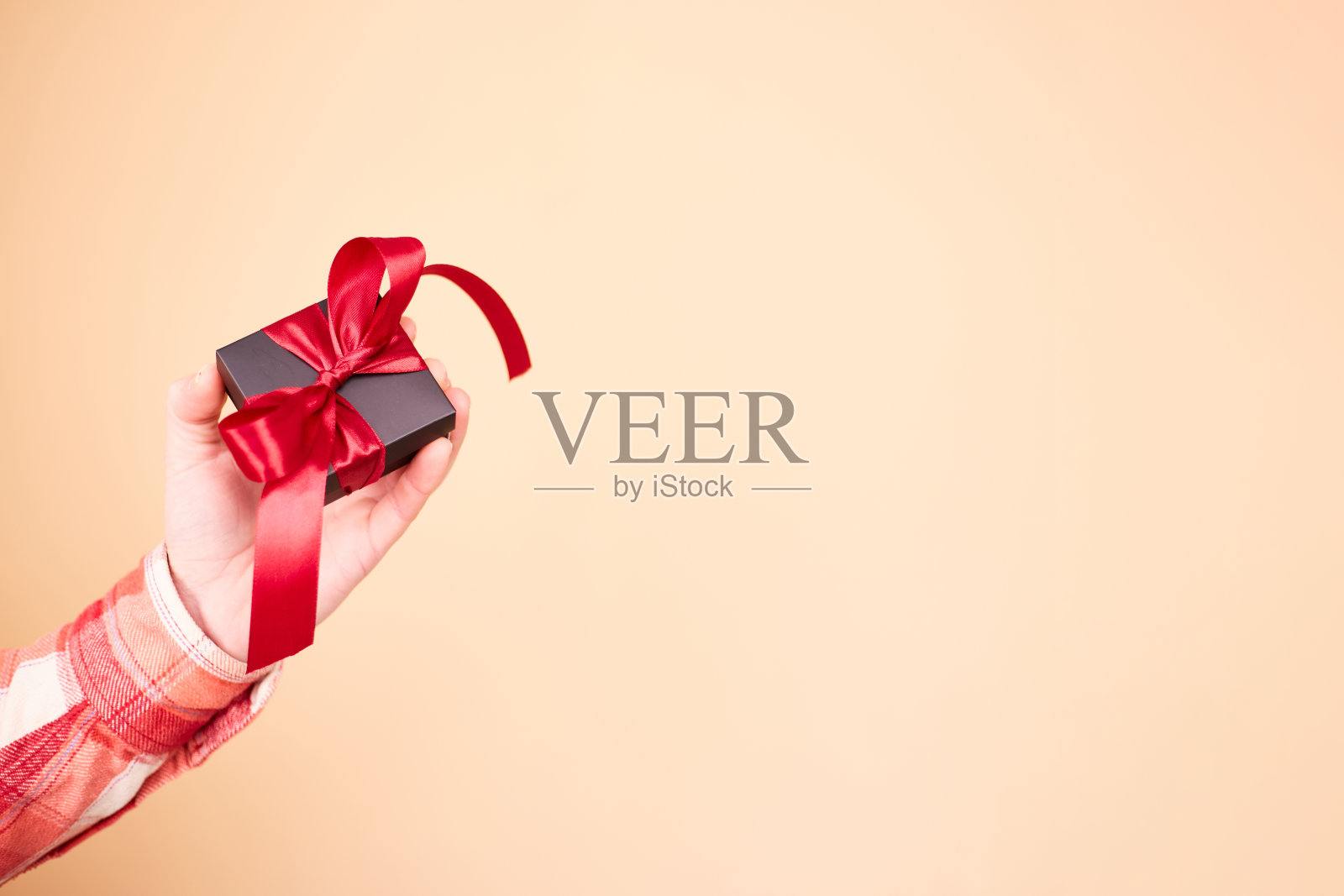 男性手中礼物盒的特写照片。拿着礼品盒的男人。情人节。生日或节日的概念。本空间照片摄影图片