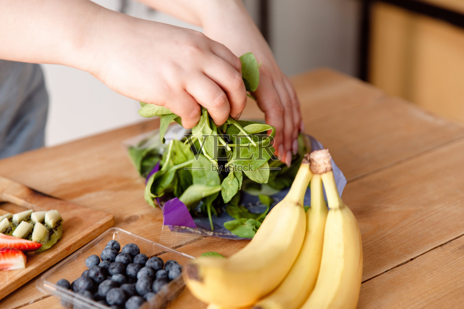 女汉斯正在切水果做冰沙。照片摄影图片