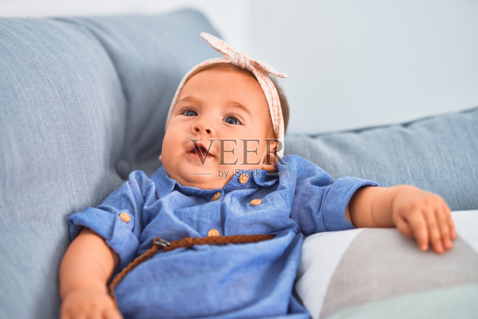 可爱的宝宝躺在家里的沙发上。新生儿放松和休息舒适照片摄影图片