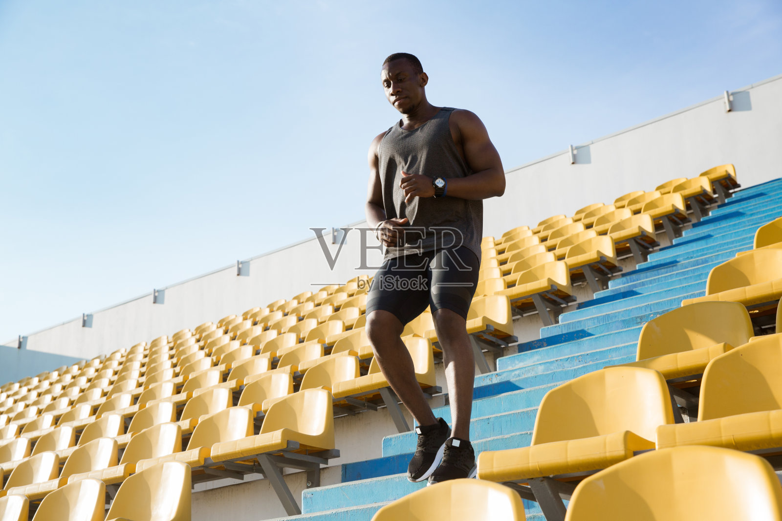 一个年轻的非洲人穿着运动服跑下楼照片摄影图片
