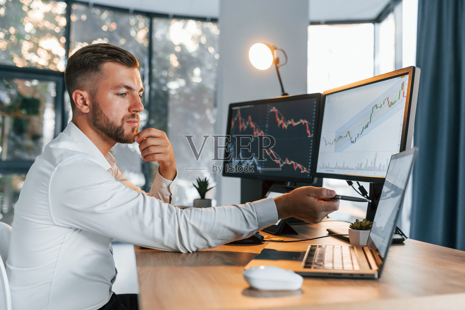 忙碌的年轻商人穿着正装，办公室里有多个屏幕照片摄影图片