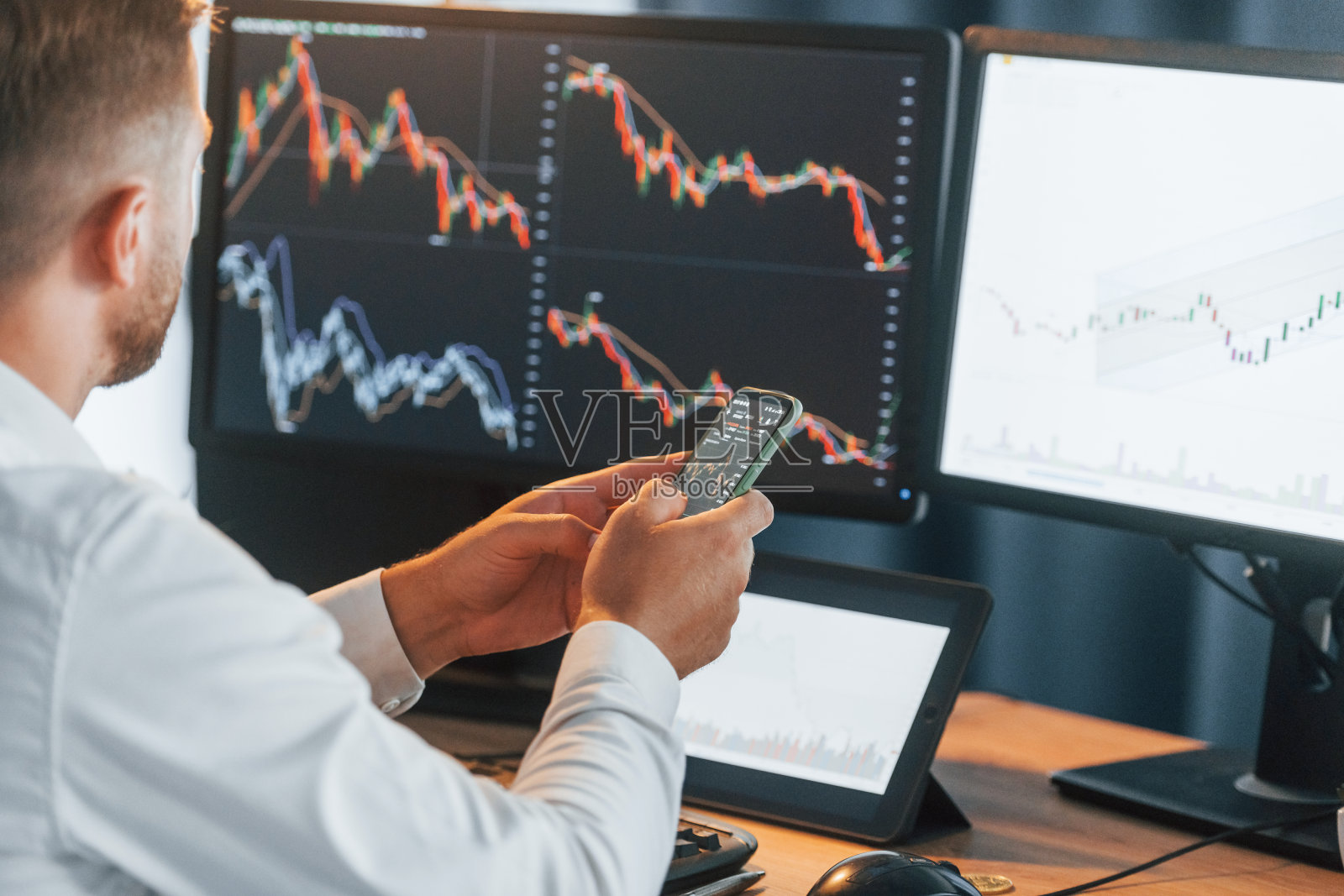 忙碌的年轻商人穿着正装，办公室里有多个屏幕照片摄影图片