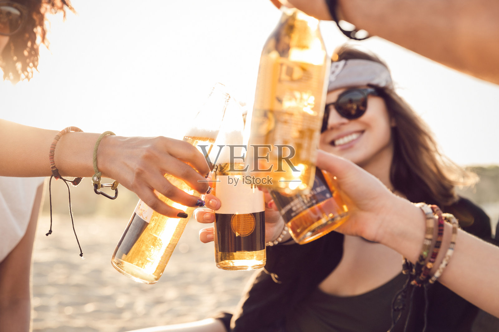 一群快乐的年轻人一起坐在海滩上照片摄影图片