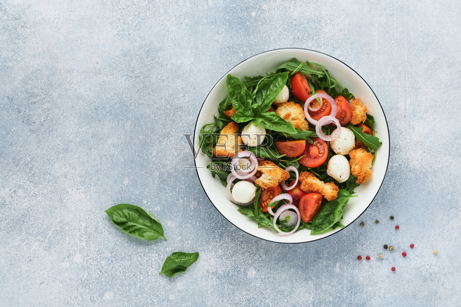 意大利面包沙拉。意大利传统食物，浅灰色背景上的番茄，马苏里拉奶酪球，罗勒，洋葱和面包。传统的意大利烹饪。前视图。副本的空间。照片摄影图片