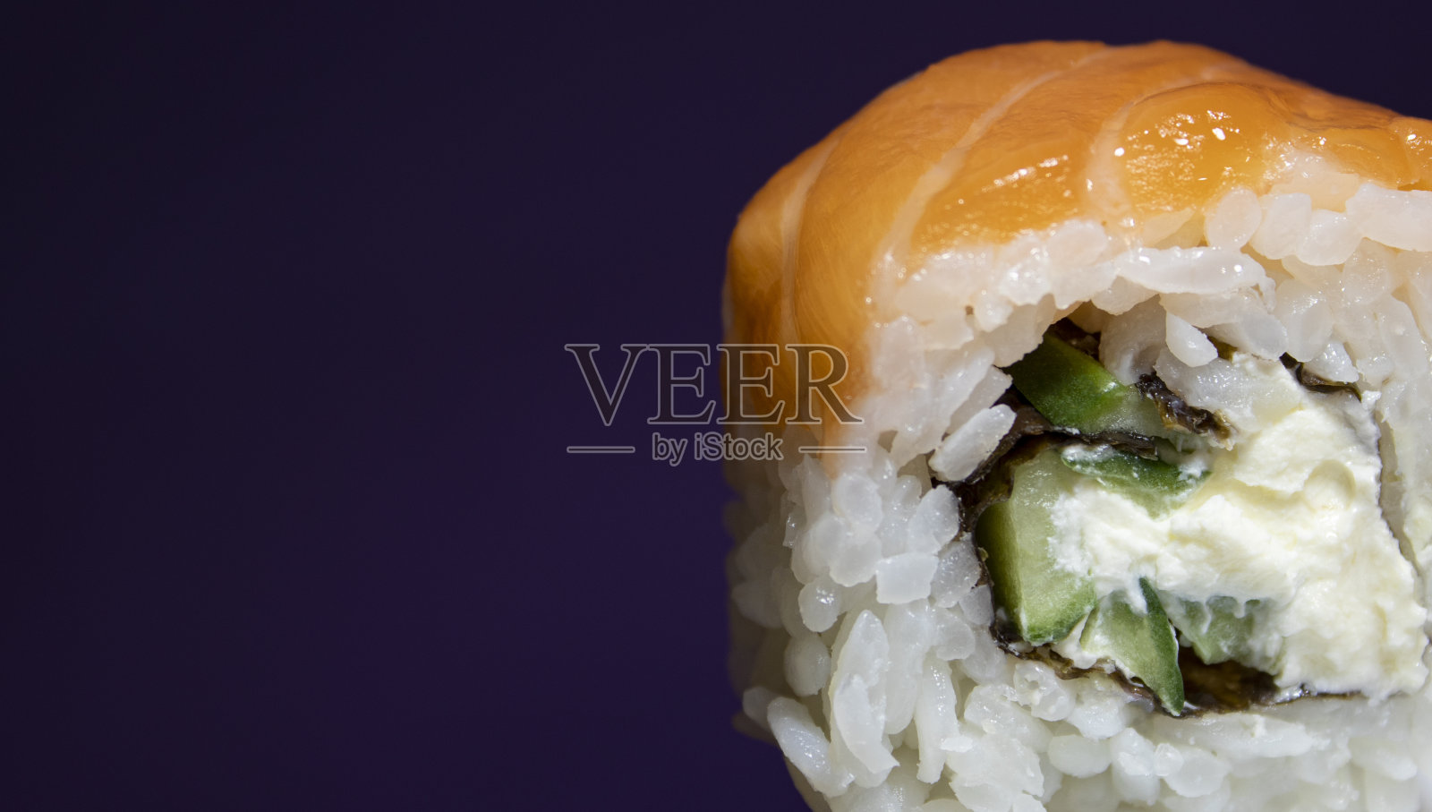 紫色背景的三文鱼寿司特写。传统的日本寿司。特写镜头新鲜的寿司。日本的食物。寿司手握寿司由米饭，三文鱼片组成。照片摄影图片