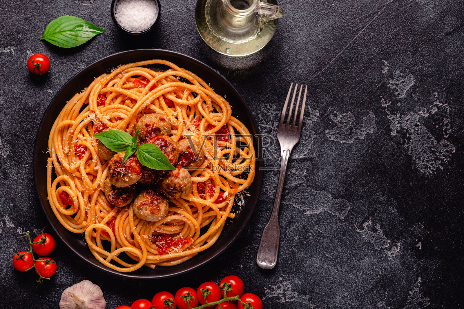 意大利面，肉丸和番茄酱，背景是石头照片摄影图片