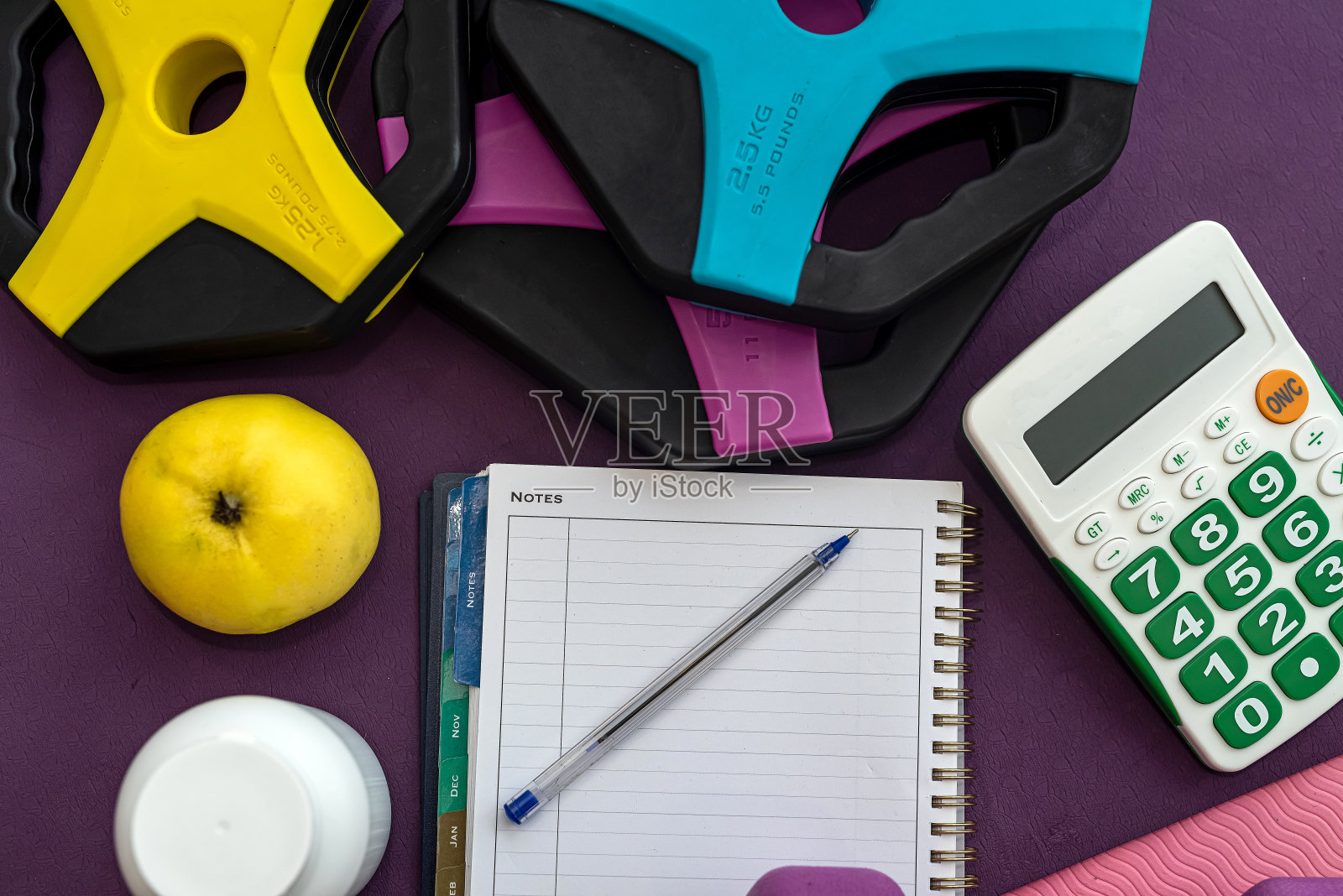 运动器材，哑铃，笔记本，笔在彩色垫子上。照片摄影图片