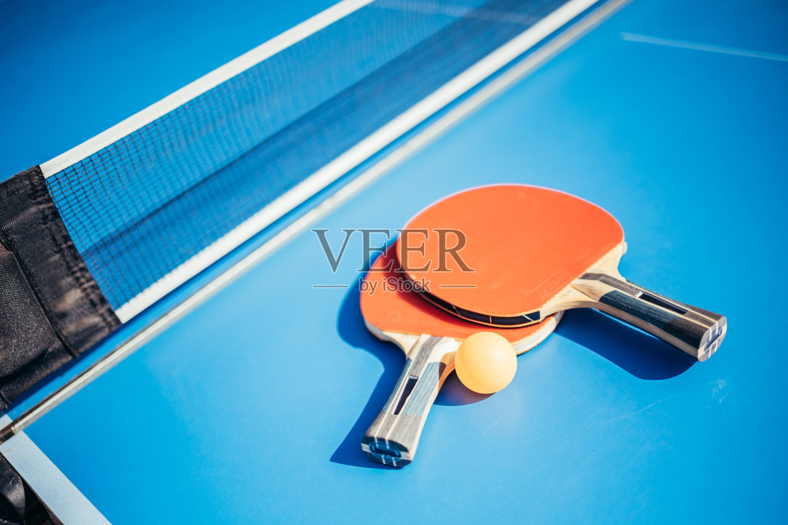 网边有两个乒乓球拍。乒乓球的概念照片摄影图片