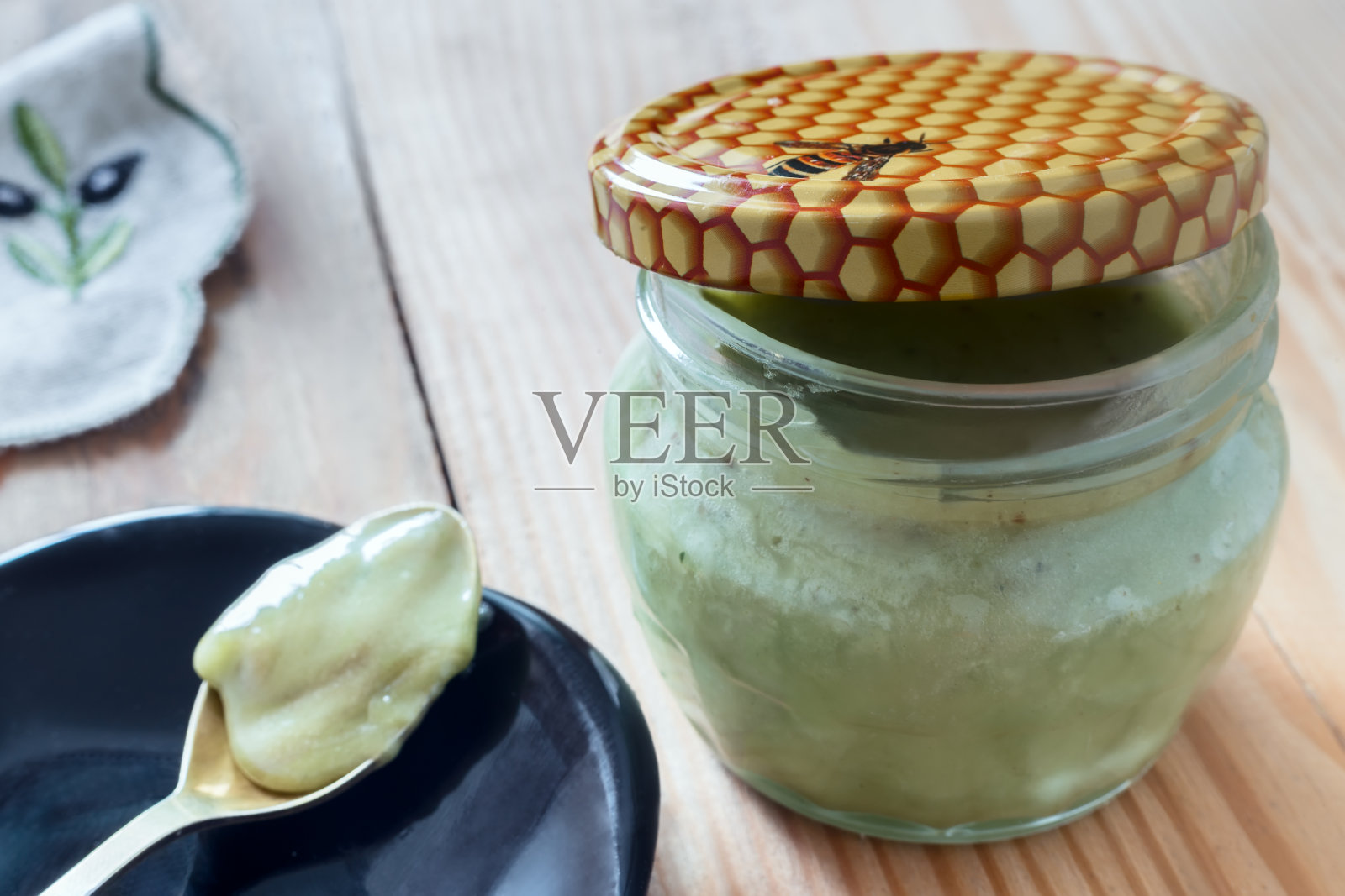 养蜂产品:蜂胶与蜂蜜装在玻璃罐中。照片摄影图片