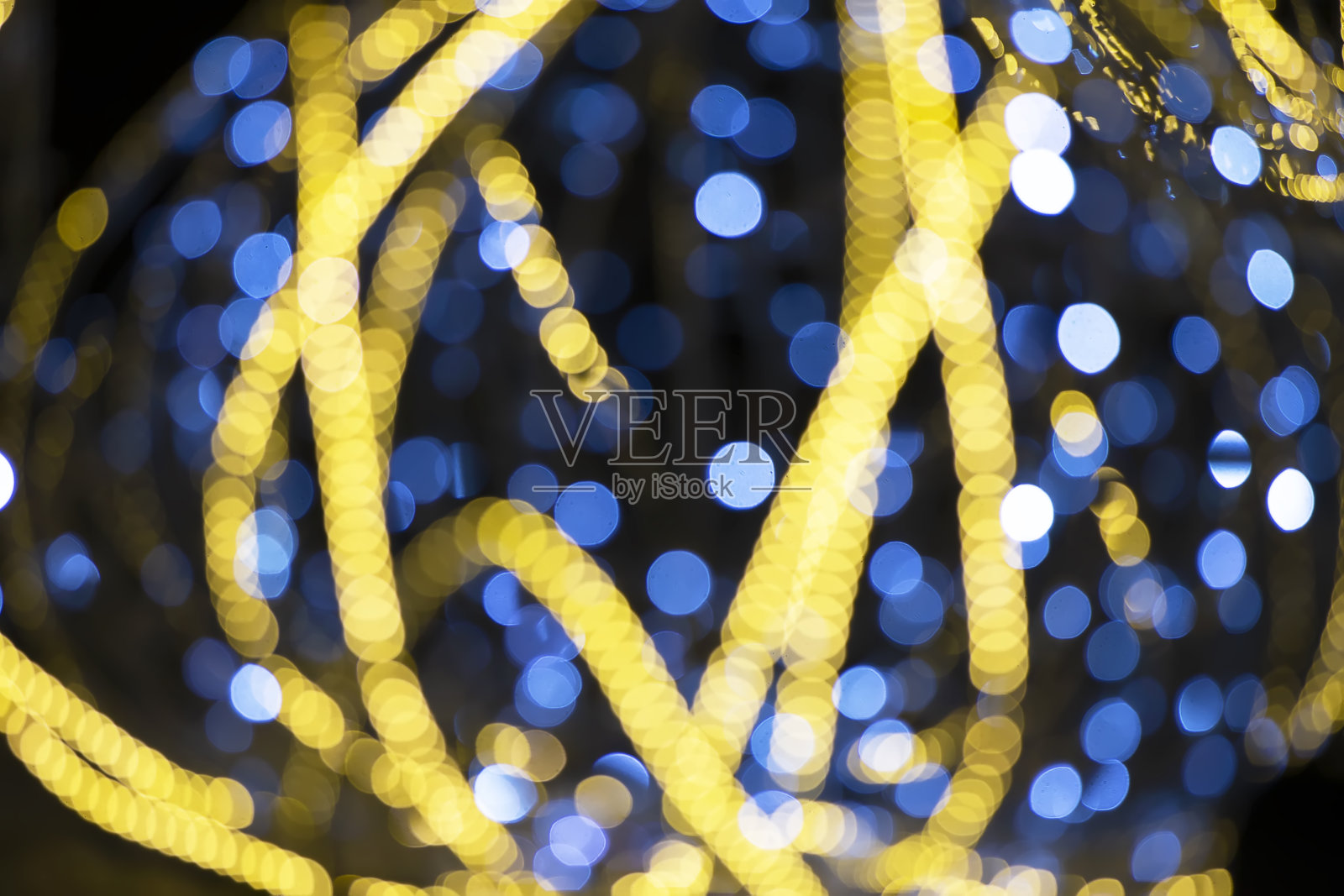 黑色背景上的蓝色和金色散景斑点。照片摄影图片