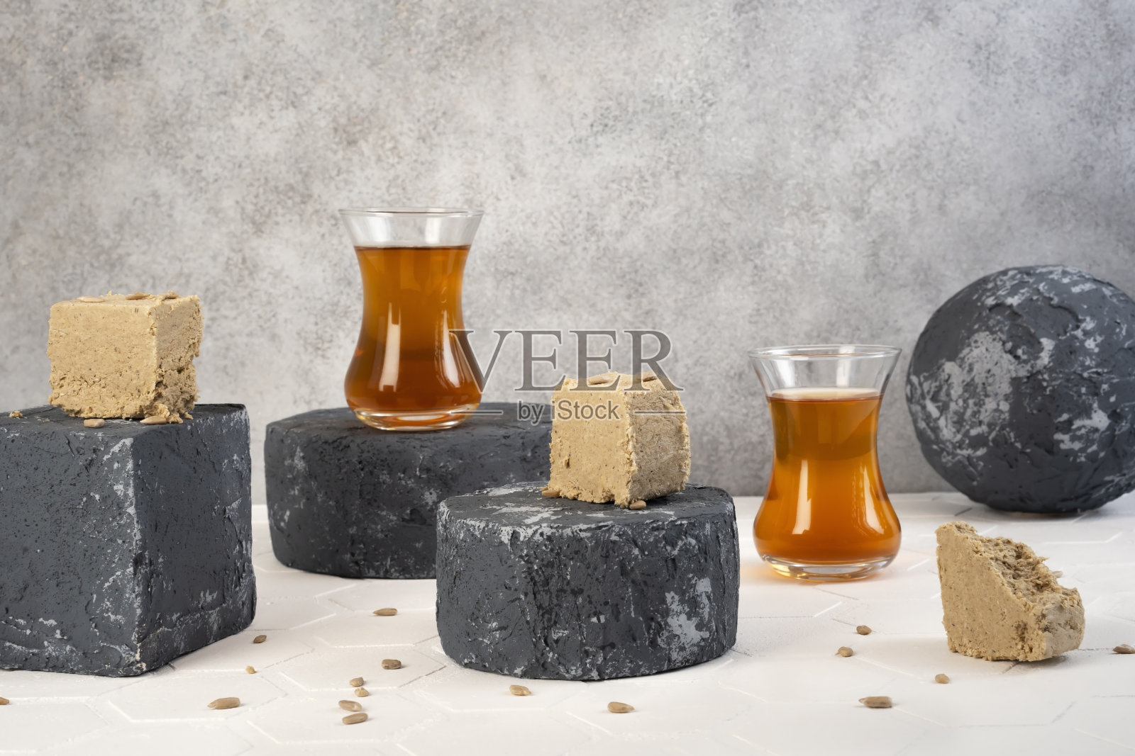 传统的东方甜点，加了葵花籽和土耳其杯子，或者是放在底座上的茶杯。背景上的冲泡茶壶照片摄影图片