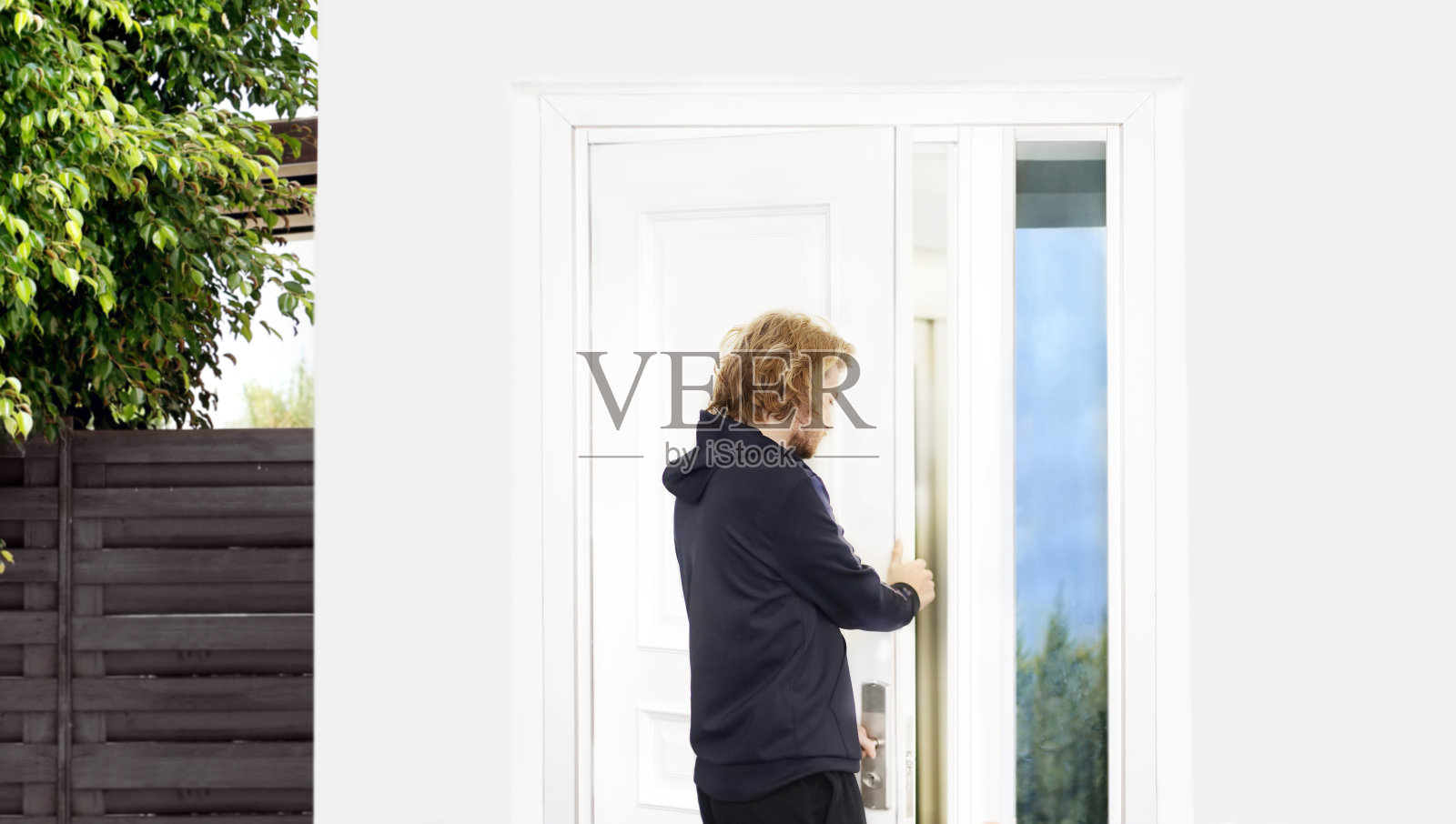 男人打开了自己家的门。照片摄影图片