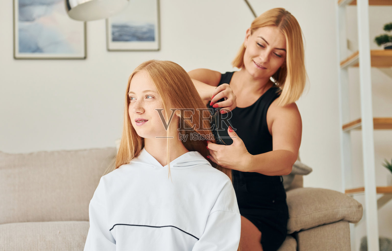 做发型。女青少年和她的母亲是在家里白天照片摄影图片