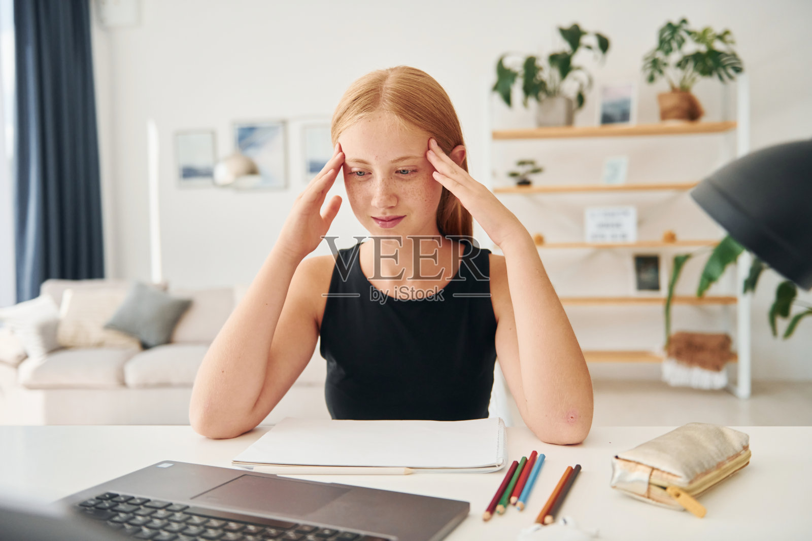 头疼。金发少女白天在家照片摄影图片