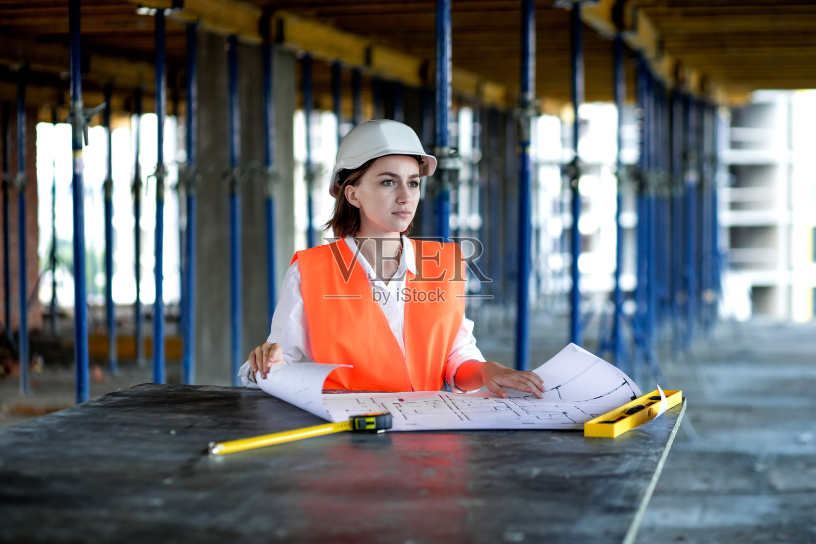 正在施工的建筑师或工程师，浏览建筑工程室内施工现场和图纸。女建筑工程师或建筑师的工作人员照片摄影图片