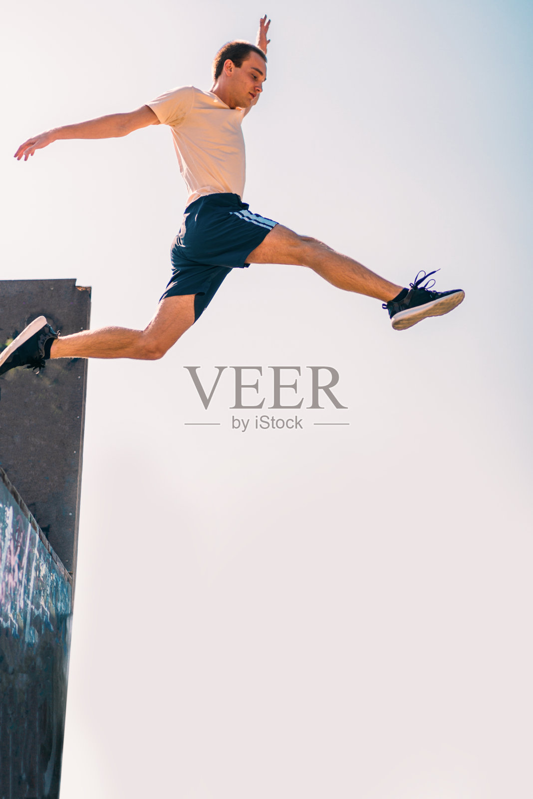 一个爱玩跑酷的男人一边跳一边玩跑酷照片摄影图片