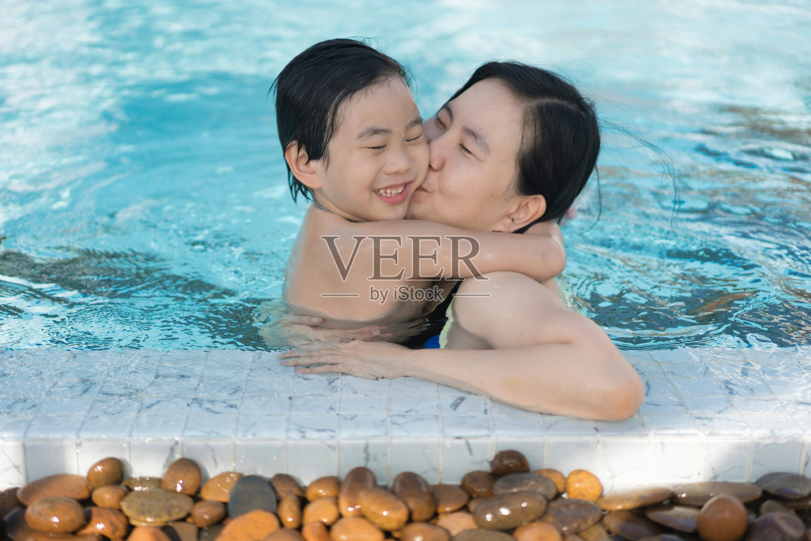 亚洲家庭，年幼的男孩和40多岁的母亲在游泳池玩得很开心照片摄影图片