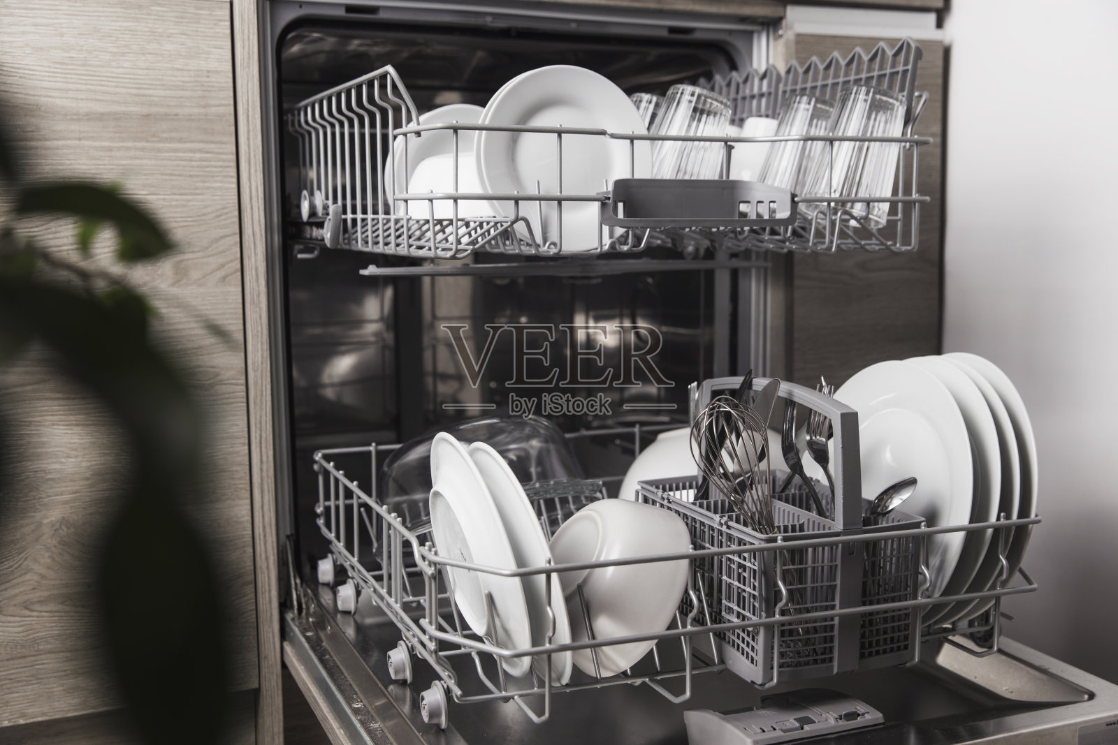 打开洗碗机，里面有干净的餐具，餐具，玻璃杯，盘子在厨房照片摄影图片
