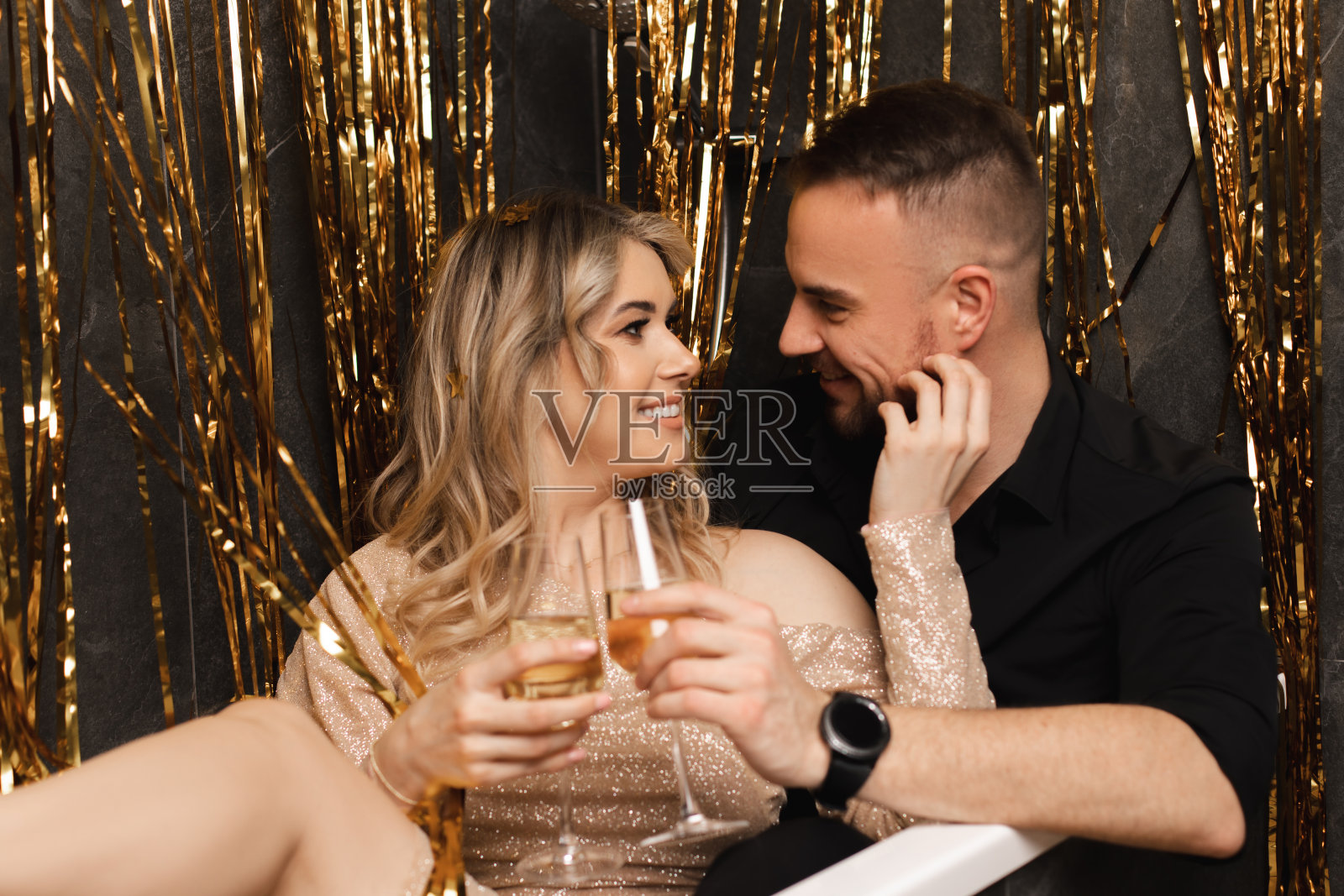 浪漫温柔的夫妇肖像女人和男人坐在浴缸喝香槟，庆祝新年附近拉梅塔照片摄影图片