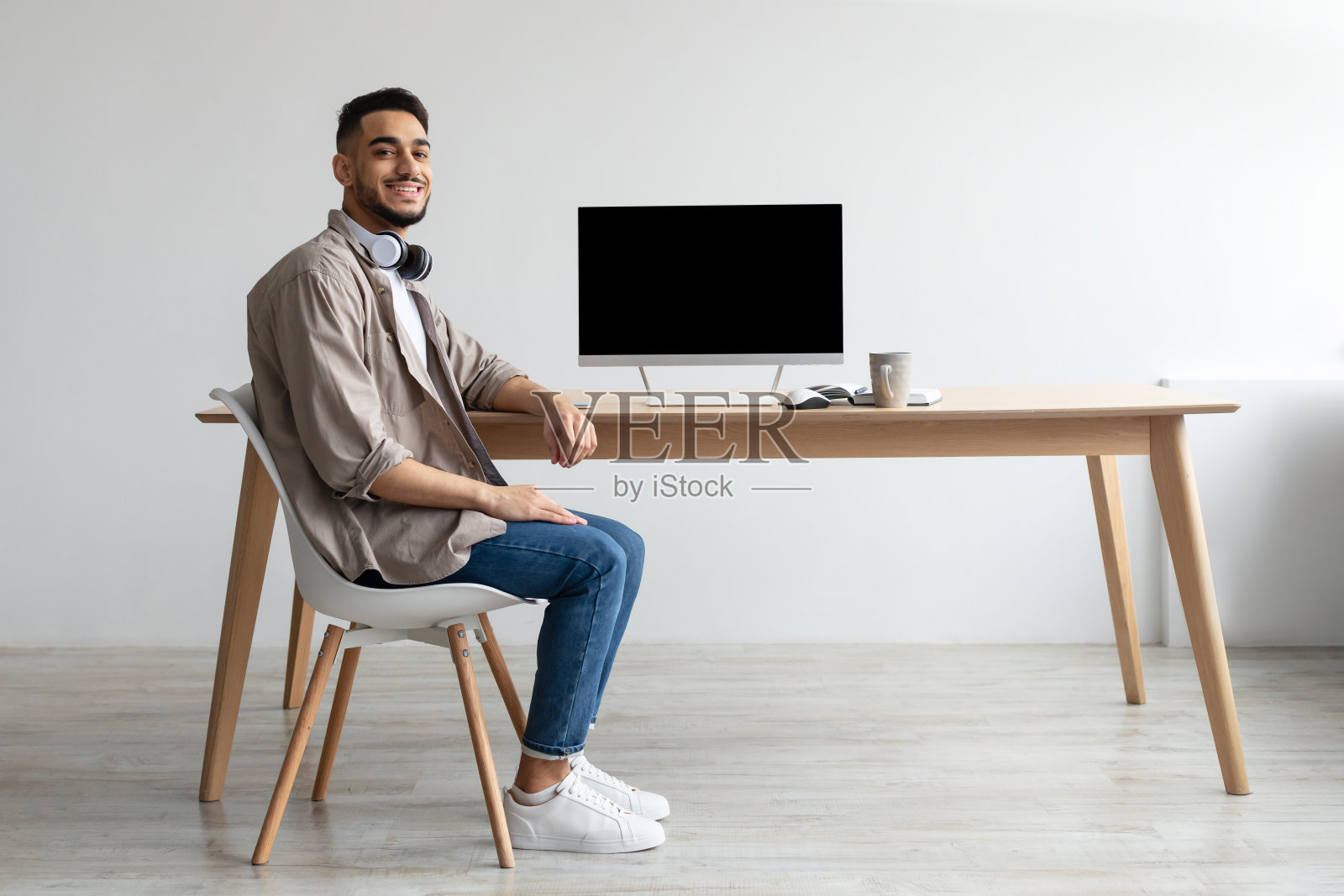 阿拉伯工人展示笔记本电脑与黑色空屏幕，模型照片摄影图片