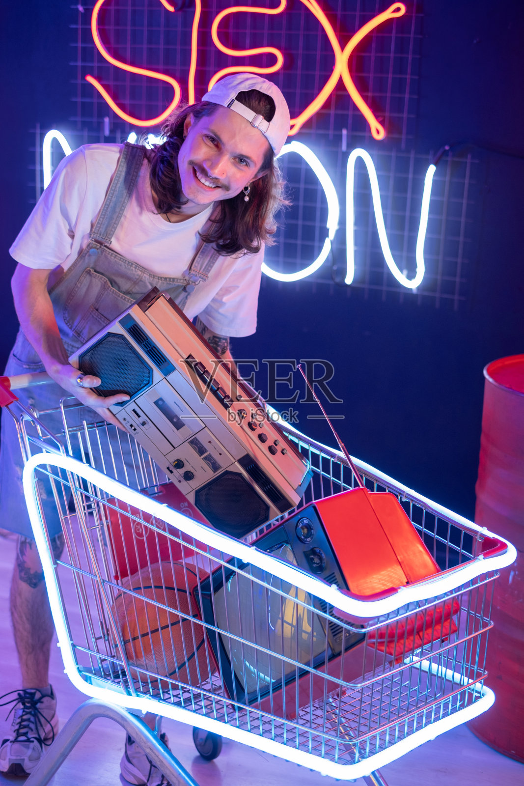 千禧一代的男人在老式商店里买录音机和电视照片摄影图片