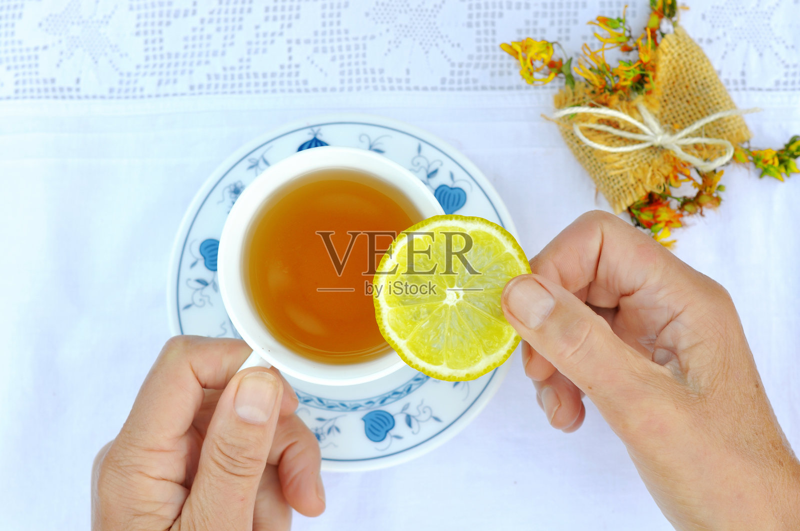 女人手拿饼干喝草药热茶照片摄影图片