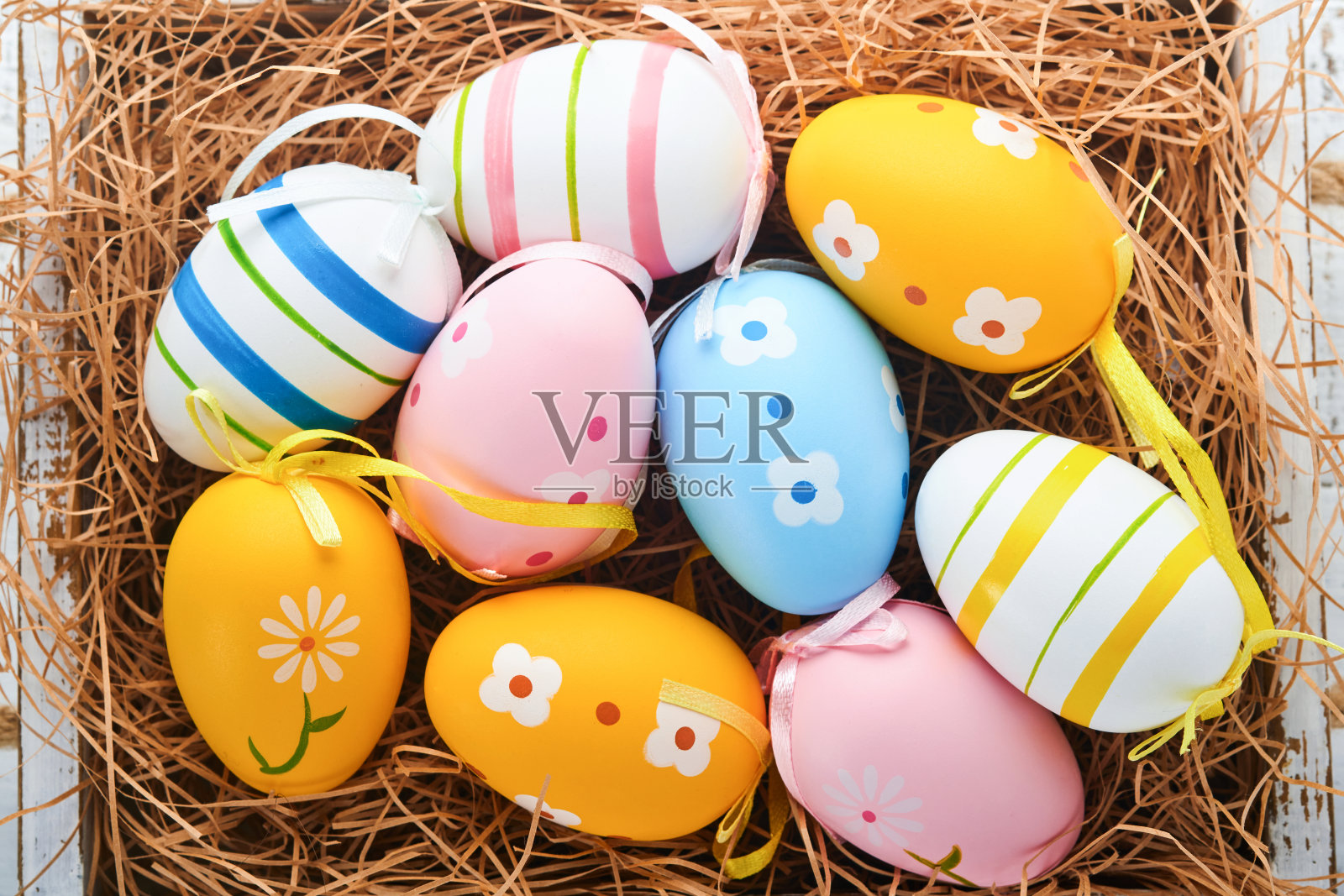 复活节假期。在白色的木制篮子上的彩色复活节彩蛋。复活节贺卡。俯视图，复制空间。照片摄影图片