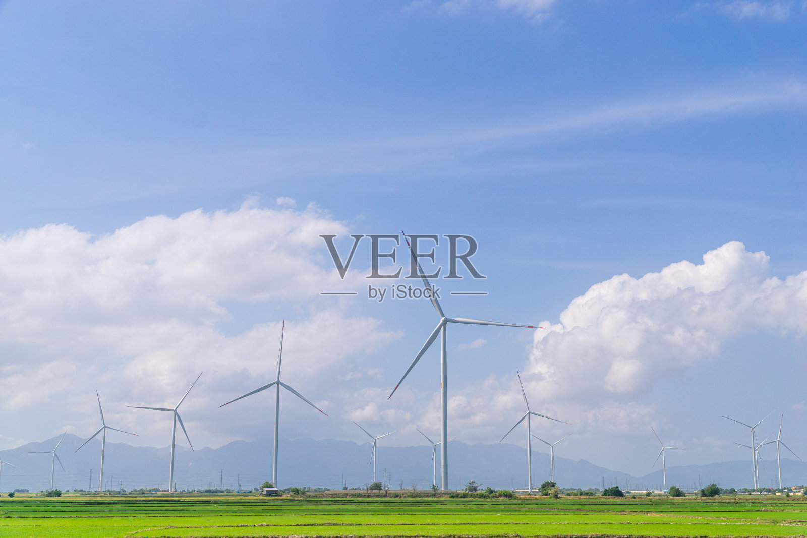 越南潘琅宁静的自然风光。在夏天，风力涡轮机在有许多树木的稻田和乡村道路上。照片摄影图片