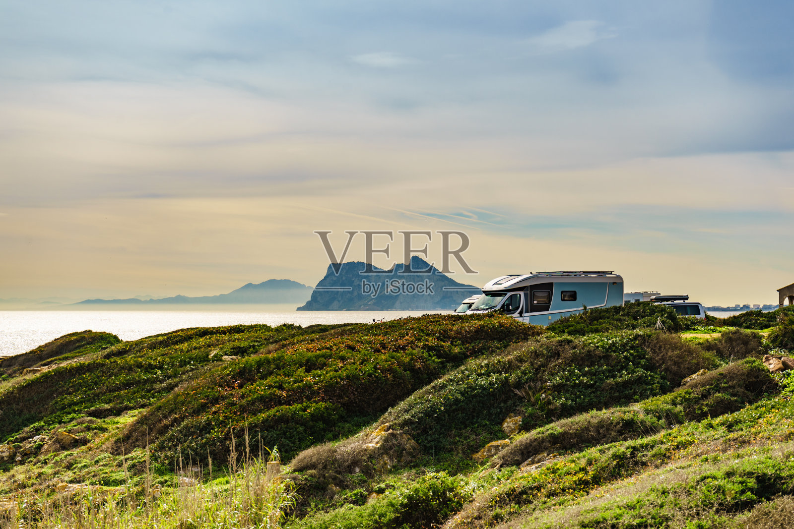 西班牙海岸上的大篷车，地平线上的直布罗陀岩石照片摄影图片