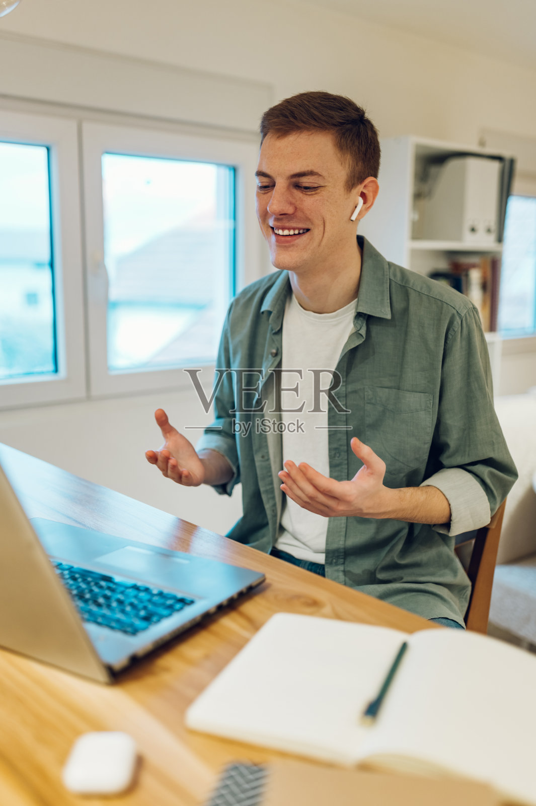 男人在家里工作的时候还在用笔记本电脑打视频电话照片摄影图片