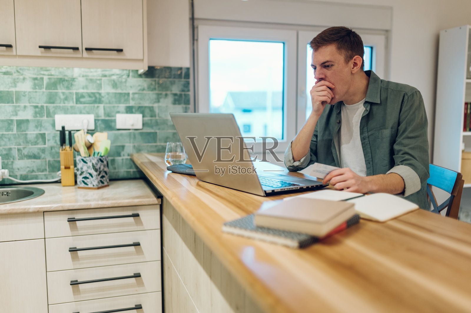 红发男人在家用笔记本电脑和信用卡照片摄影图片