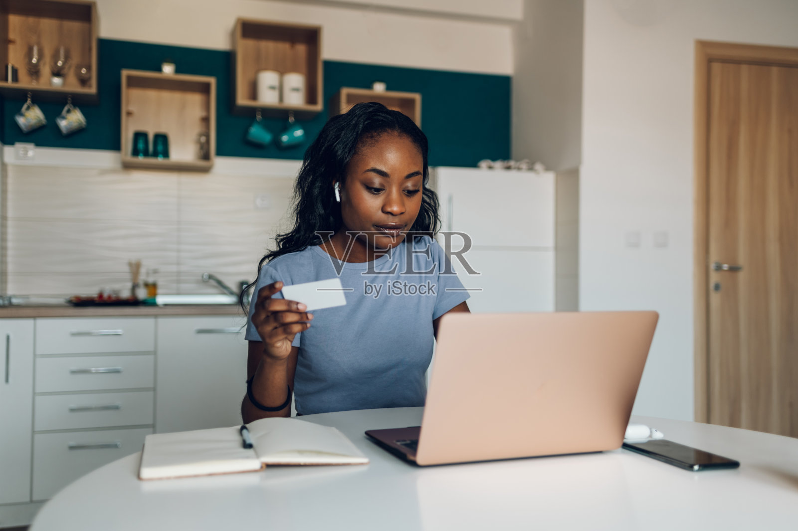 非裔美国妇女在家里使用笔记本电脑和信用卡照片摄影图片