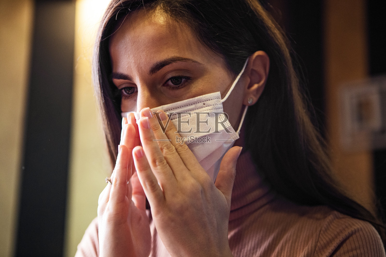 年轻女子戴着医用口罩，以保护自己免受病毒侵害照片摄影图片