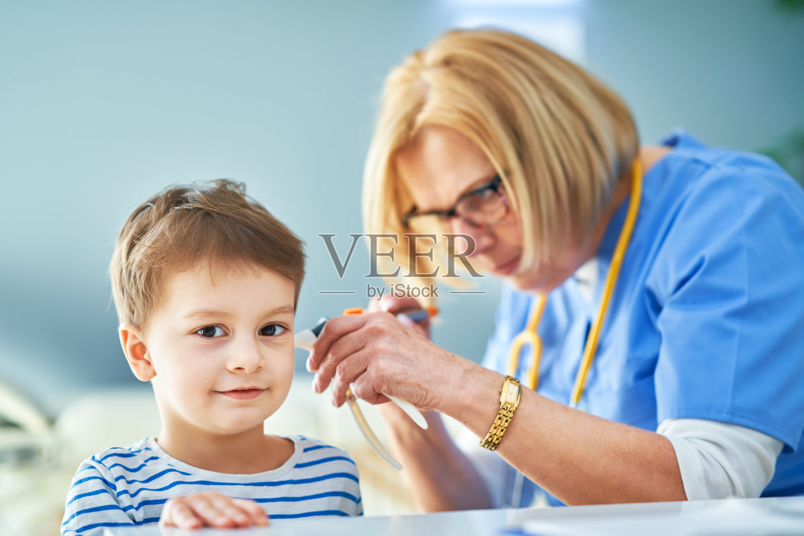 儿科医生在诊所检查小孩的耳朵照片摄影图片