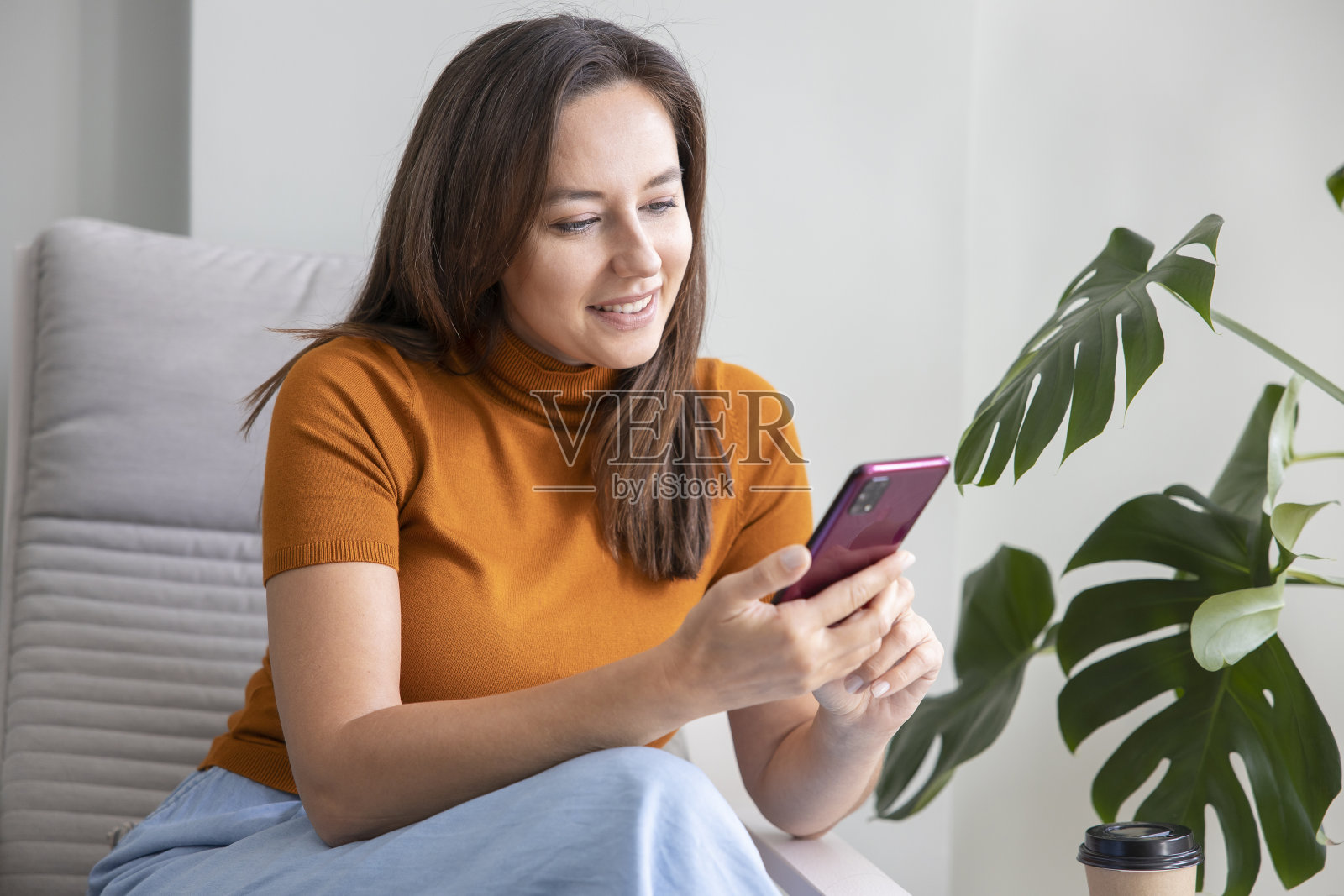 年轻女子在家用手机照片摄影图片