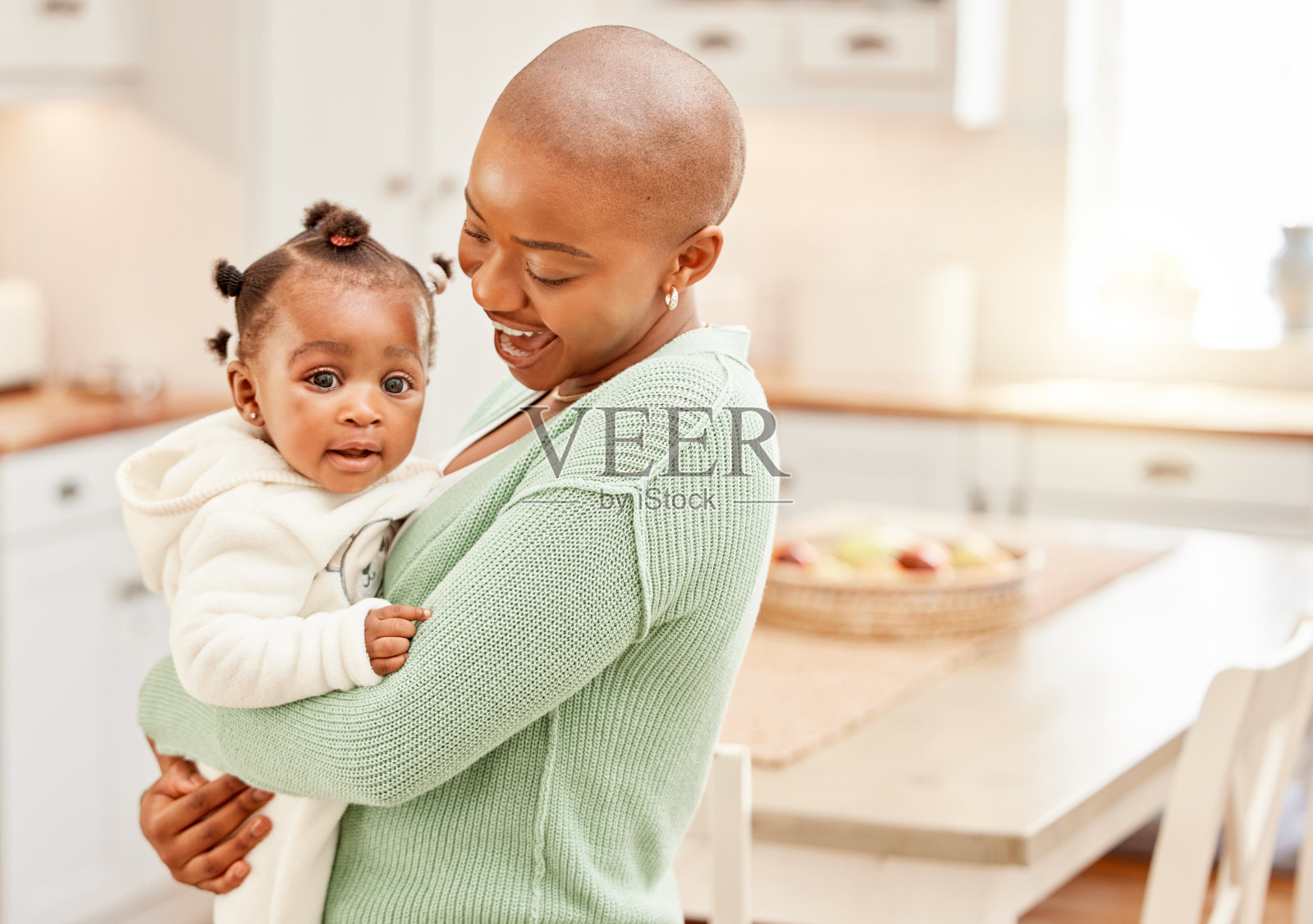 剪裁的镜头，一个有吸引力的年轻女子携带她的女儿在厨房在家里照片摄影图片