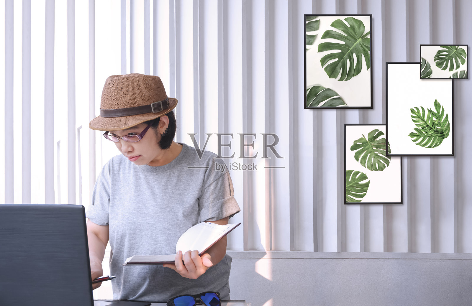 亚洲中年女性时尚设计师，穿着复古服装，在家庭办公室工作时使用笔记本电脑照片摄影图片