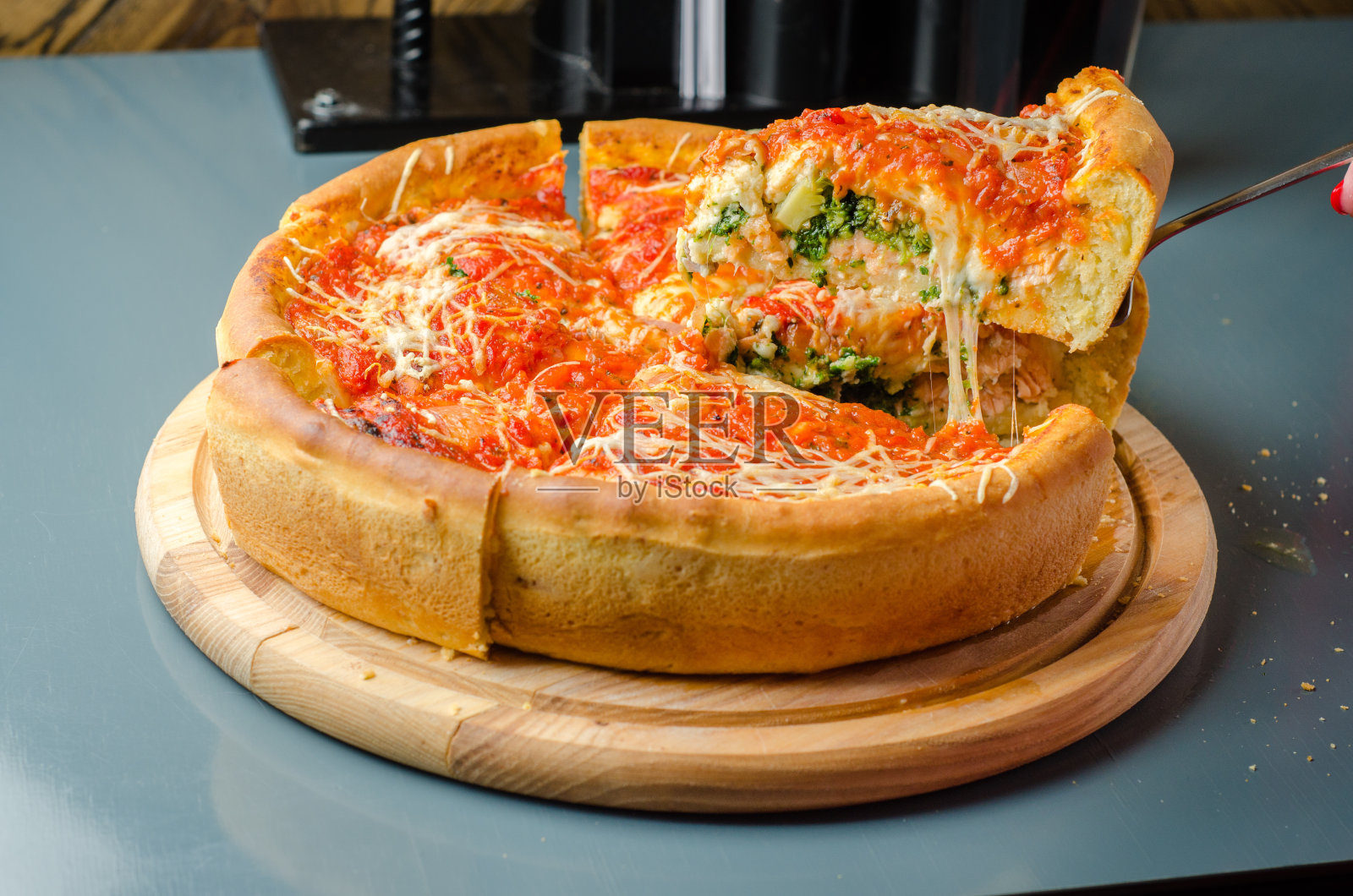 芝加哥披萨配三文鱼、菠菜、西兰花、马苏里拉芝士、去皮番茄酱和帕尔玛干酪照片摄影图片