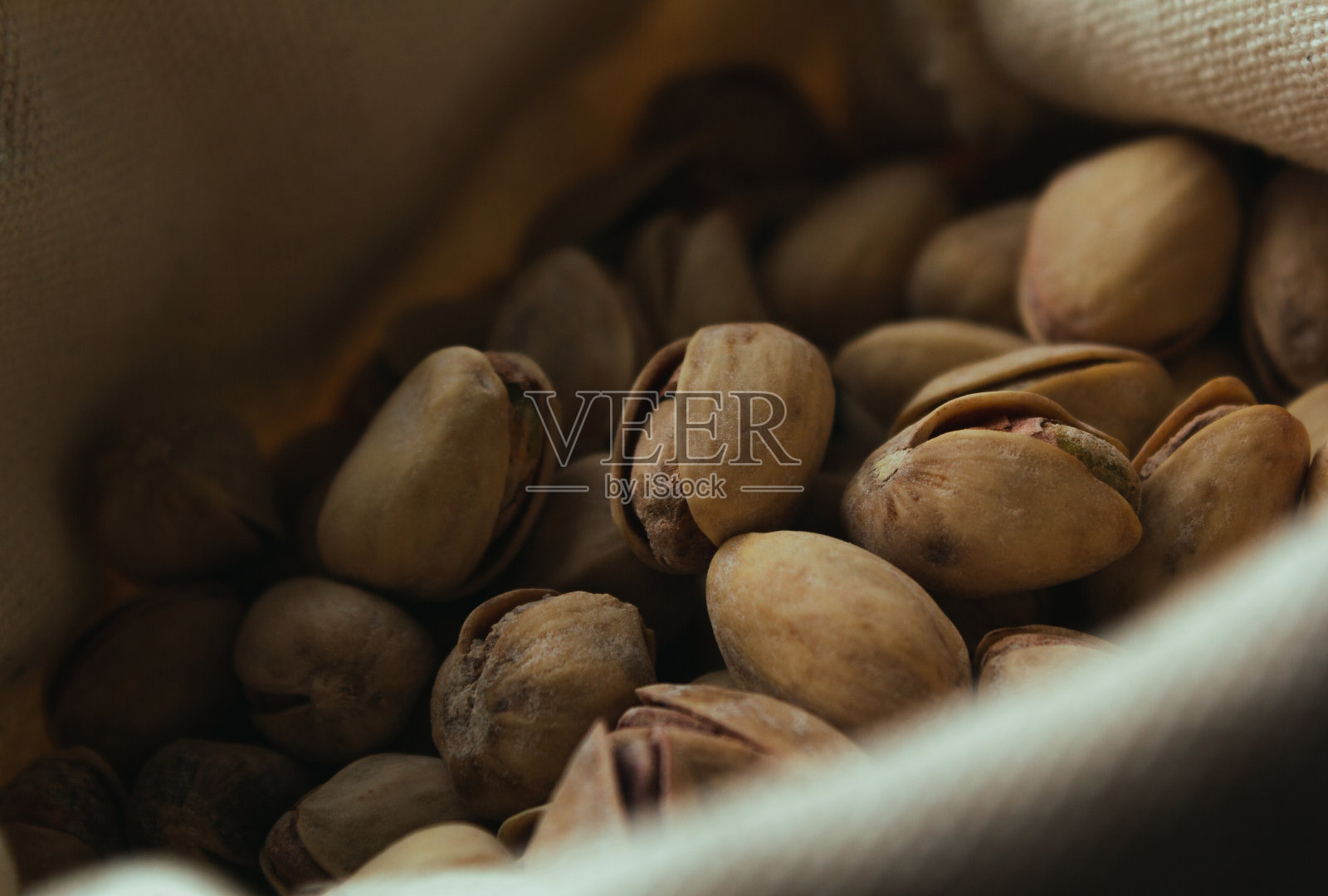 一袋烤开心果和深色背景。照片摄影图片