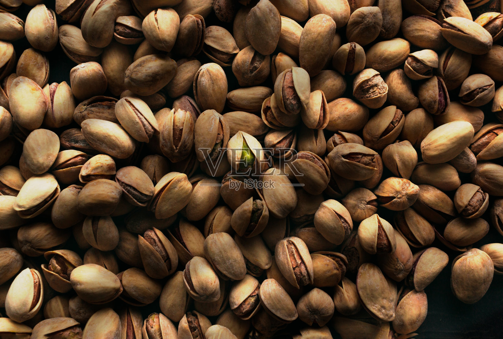 近的纹理烤开心果在黑暗的背景。照片摄影图片