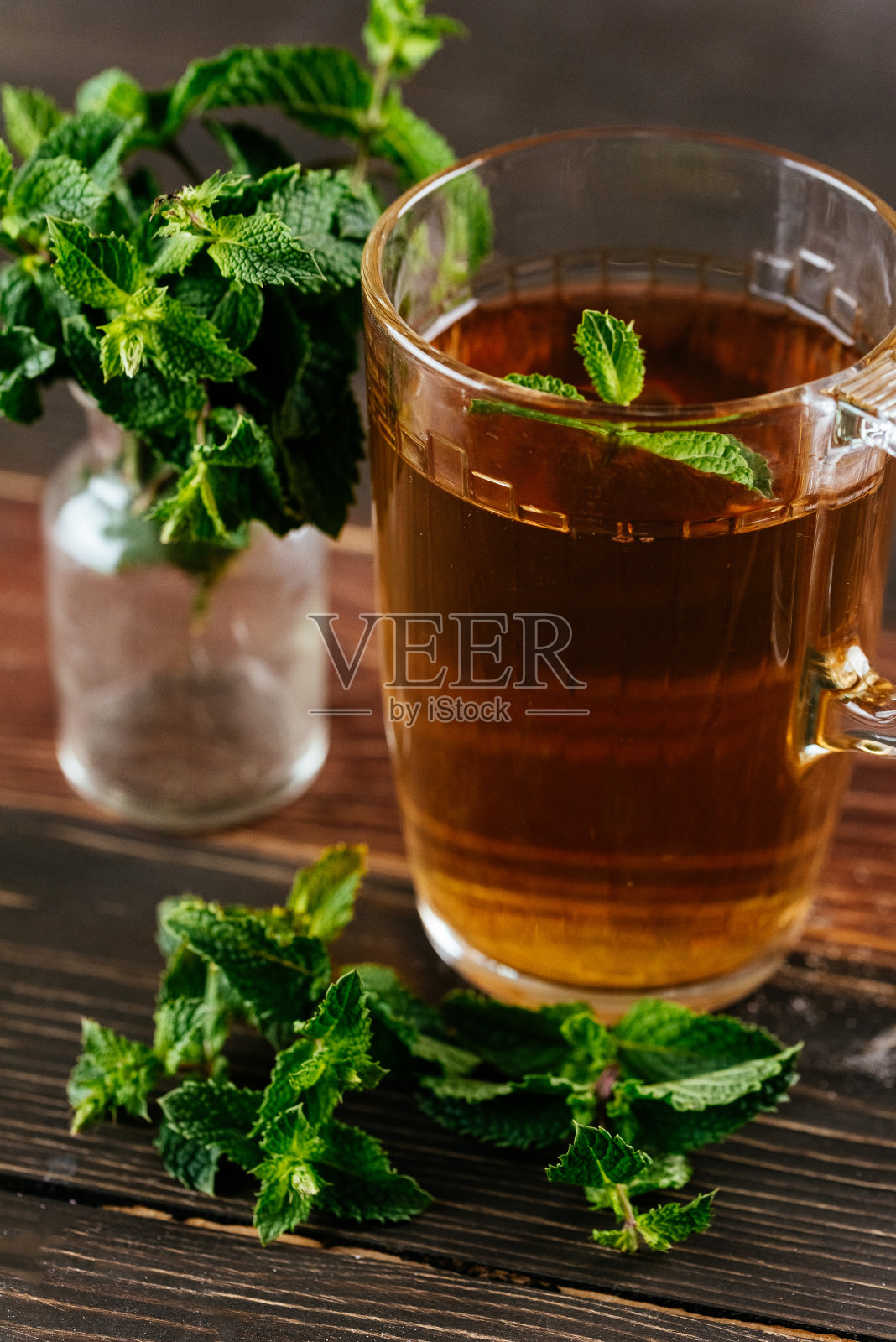 花草茶在一个美丽的杯子在一个木制的背景。照片摄影图片