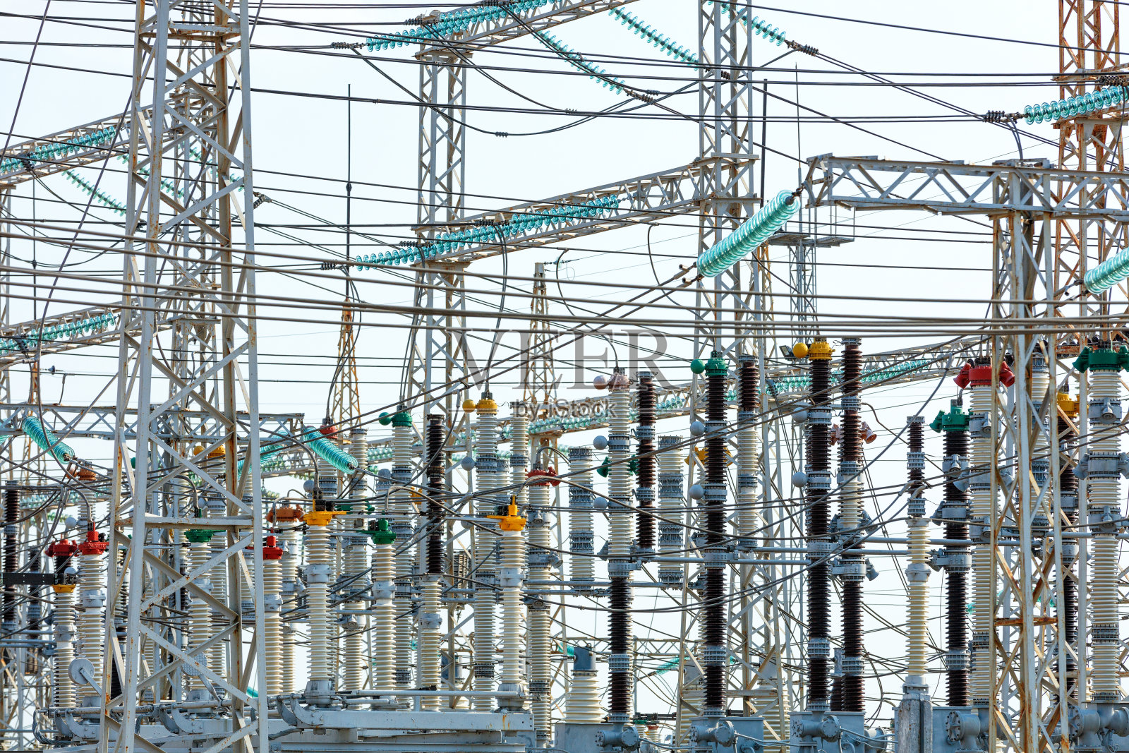 在白天，在变电站的金属桅杆上由电线和高压绝缘材料组成的网。照片摄影图片